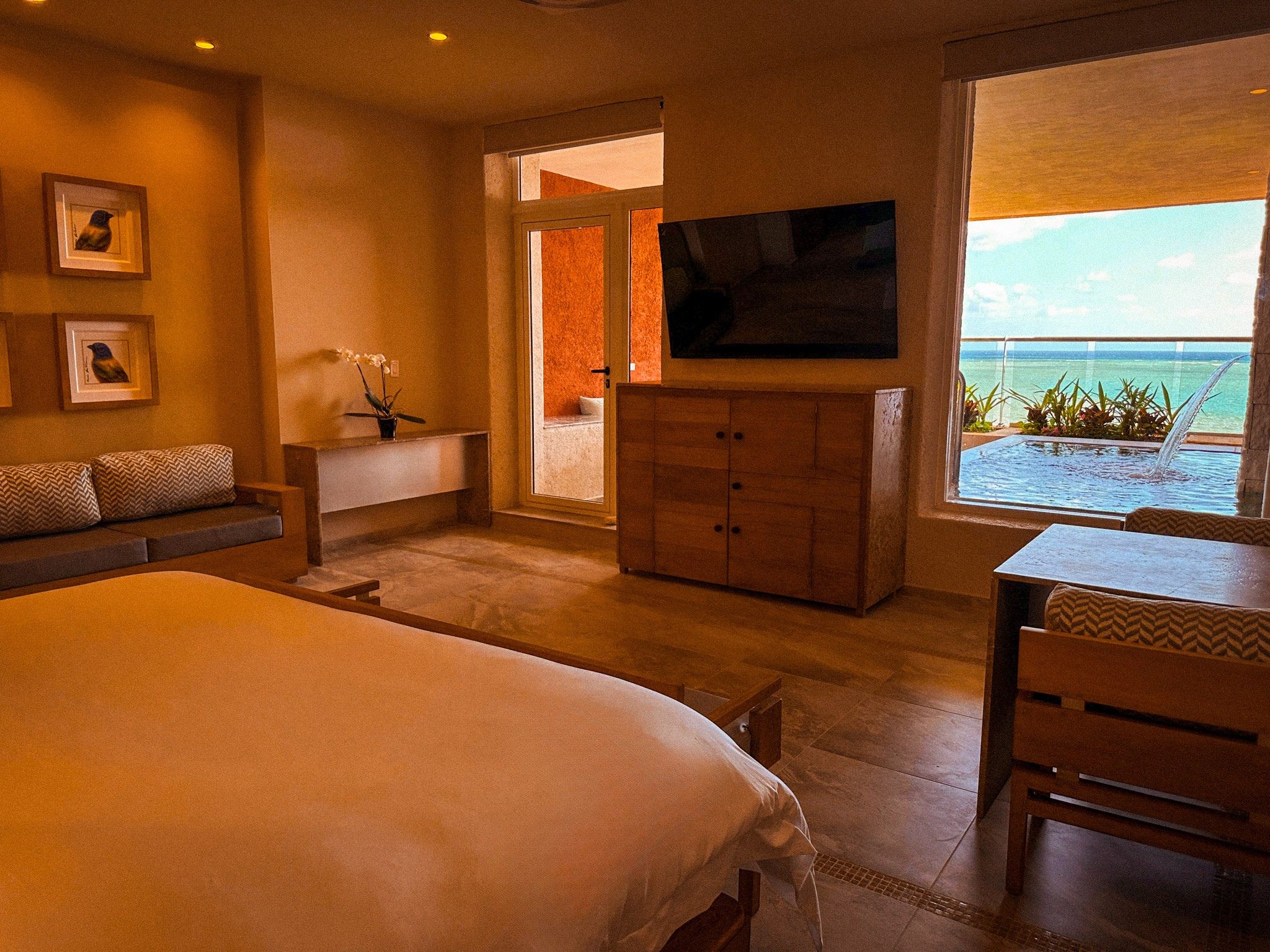 a room with a television and a pool in the background