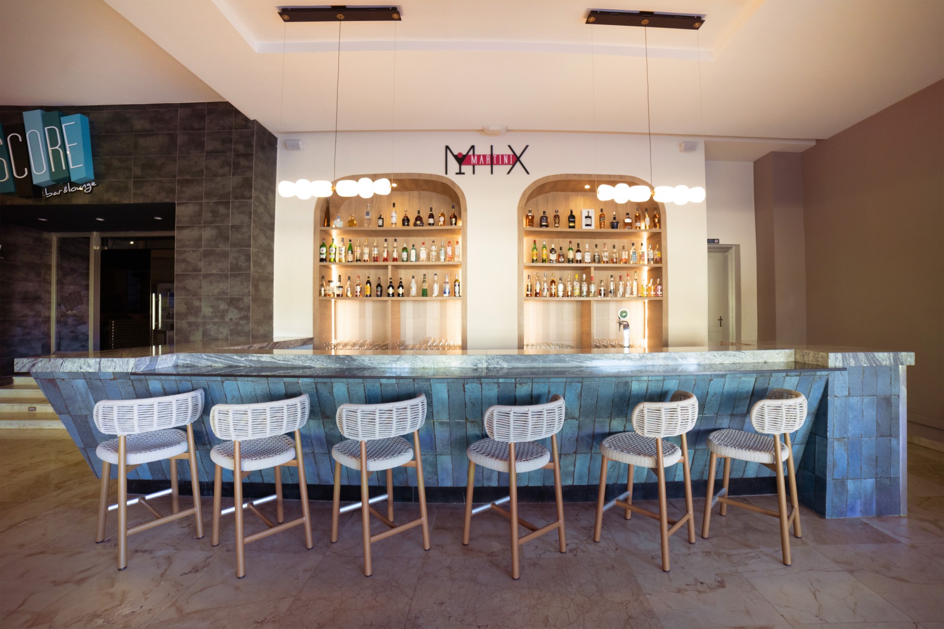 a bar with chairs and shelves of bottles