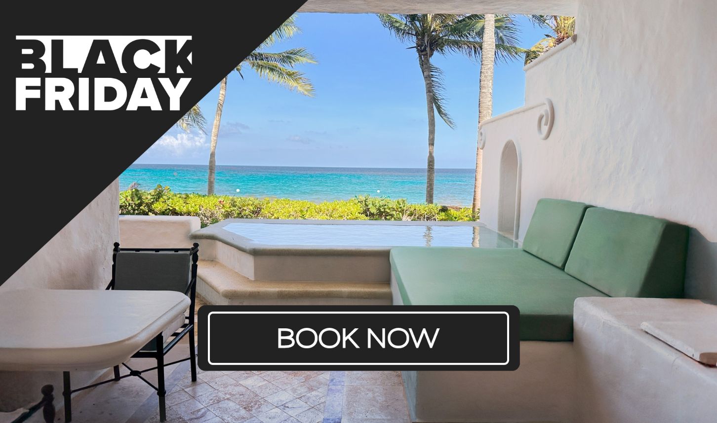 a patio with a bed and chairs and a body of water