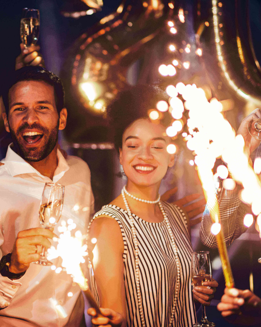 a man and woman holding sparklers