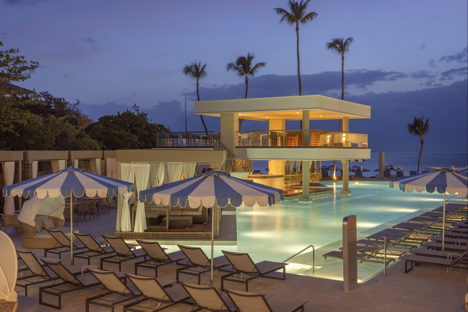 a pool with umbrellas and chairs by a building