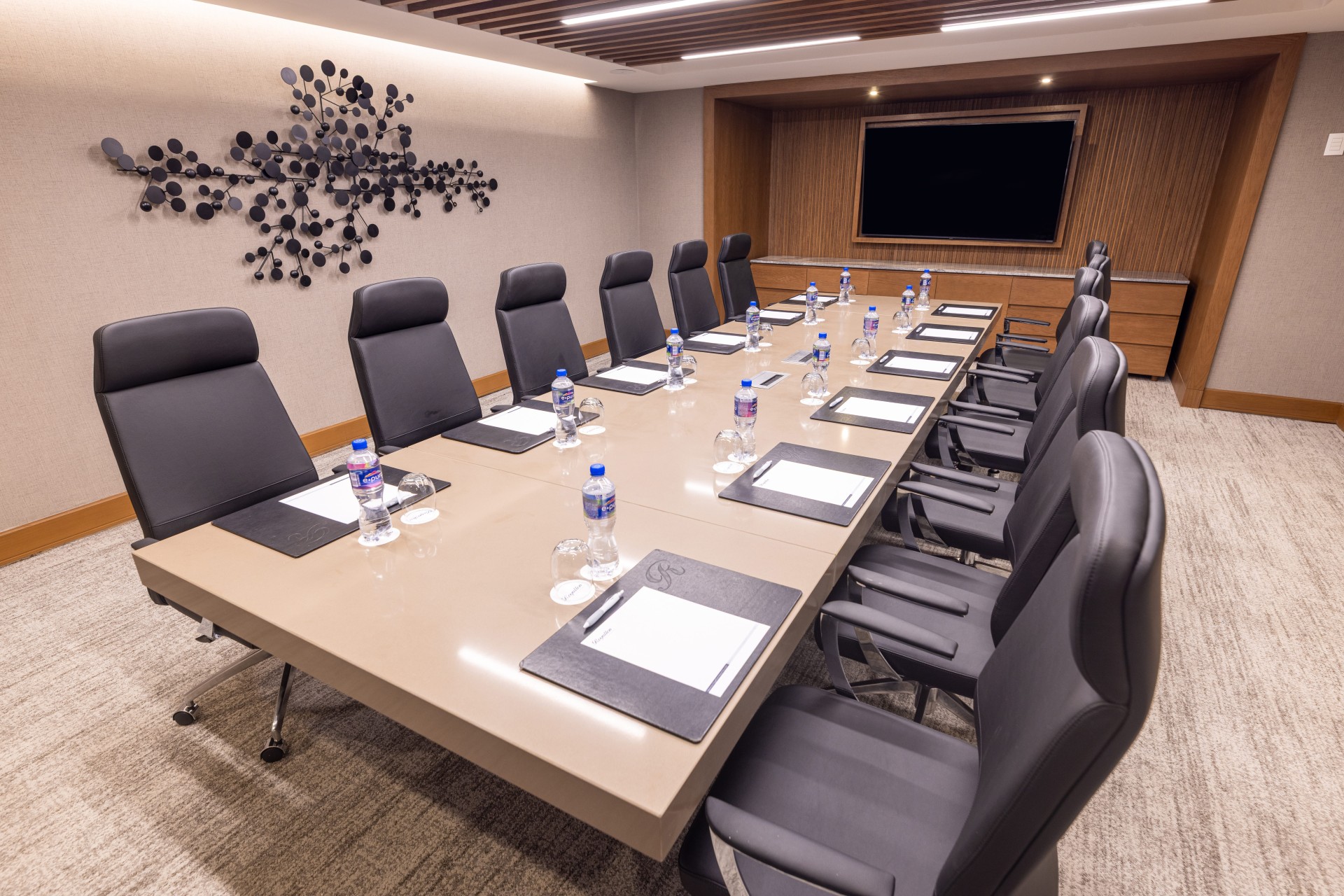 a conference room with chairs and a table with papers and a screen