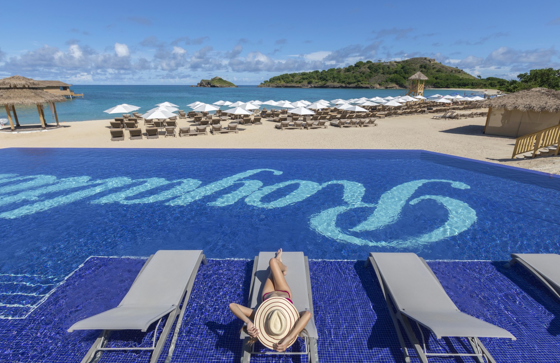 a woman lying on a lounge chair by a pool