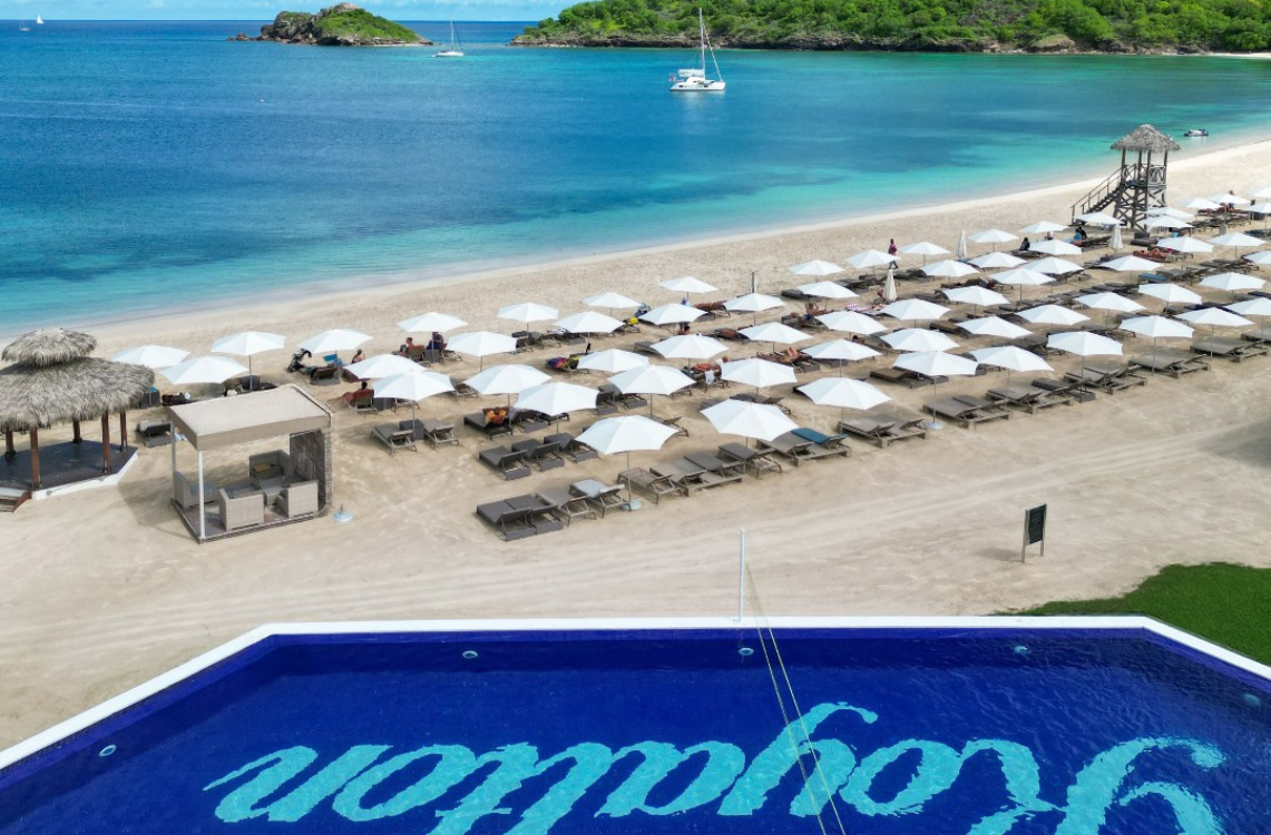 a beach with umbrellas and chairs and a pool