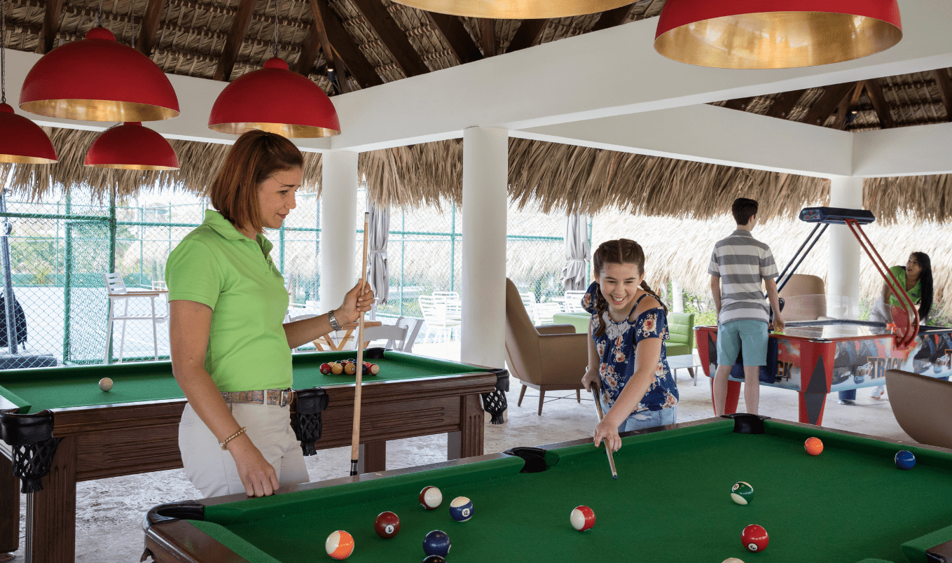 a woman and girl playing pool