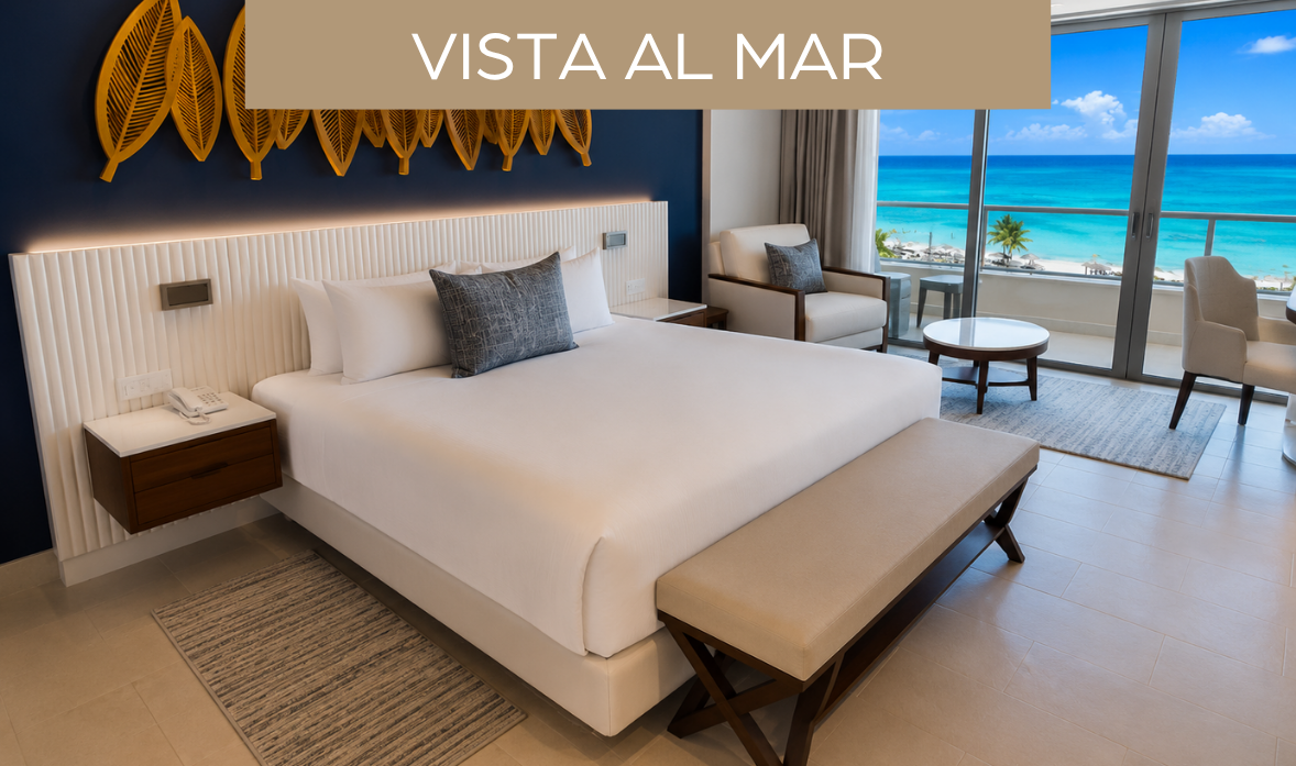 a bed with a bench and chairs in a room with a view of the ocean