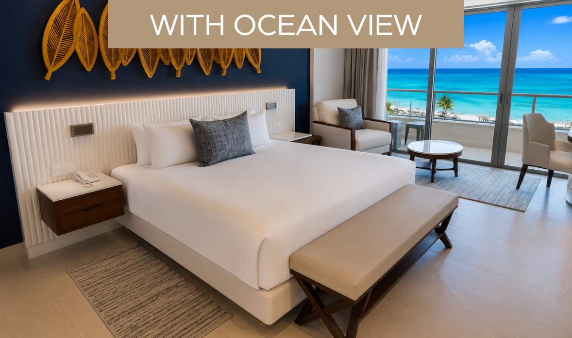 a bed with a bench and chairs in a room with a view of the ocean