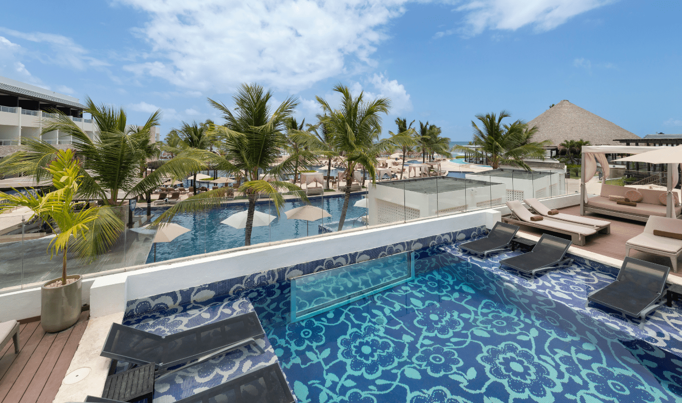 a pool with chairs and umbrellas on a rooftop