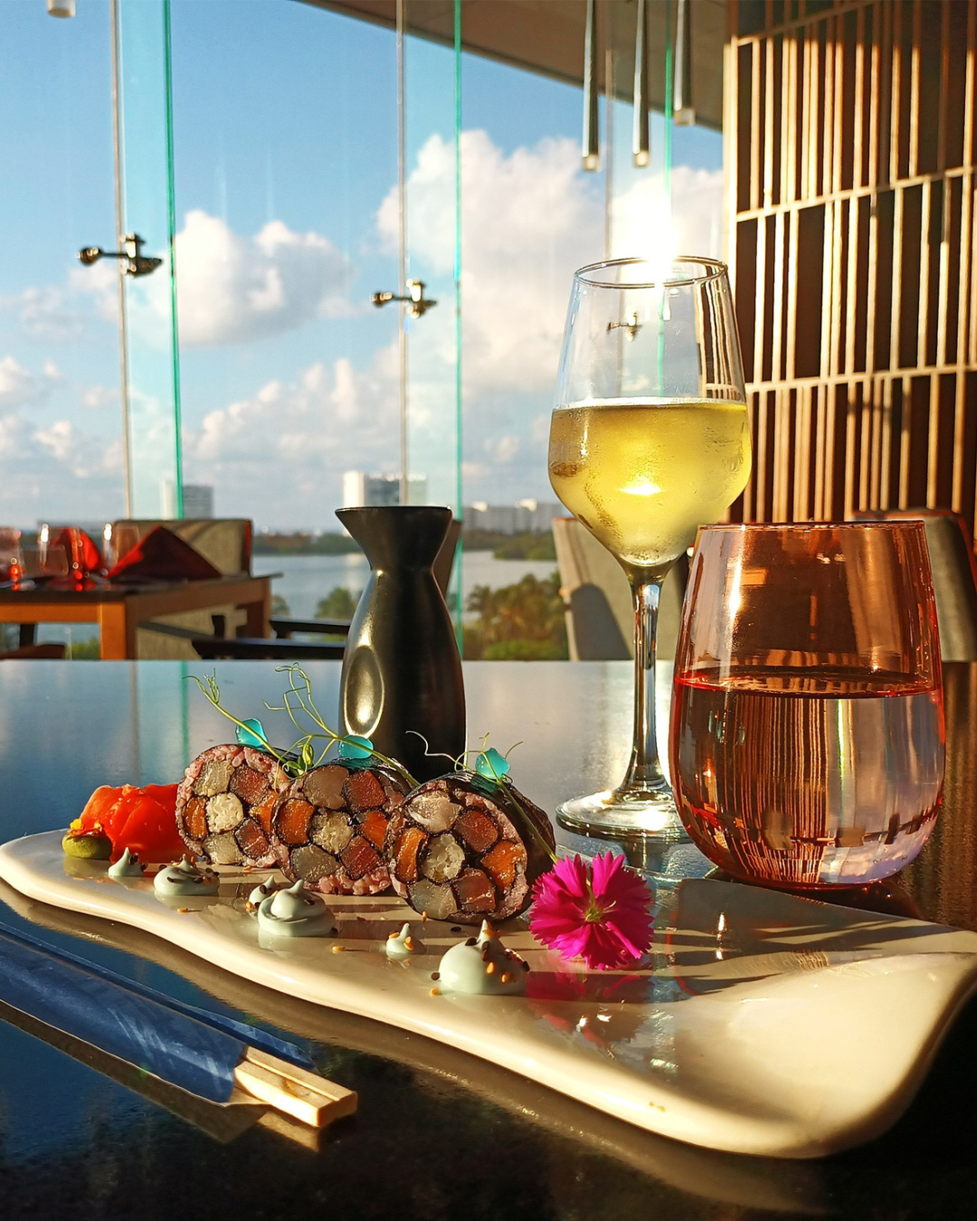 a plate of sushi and a glass of wine