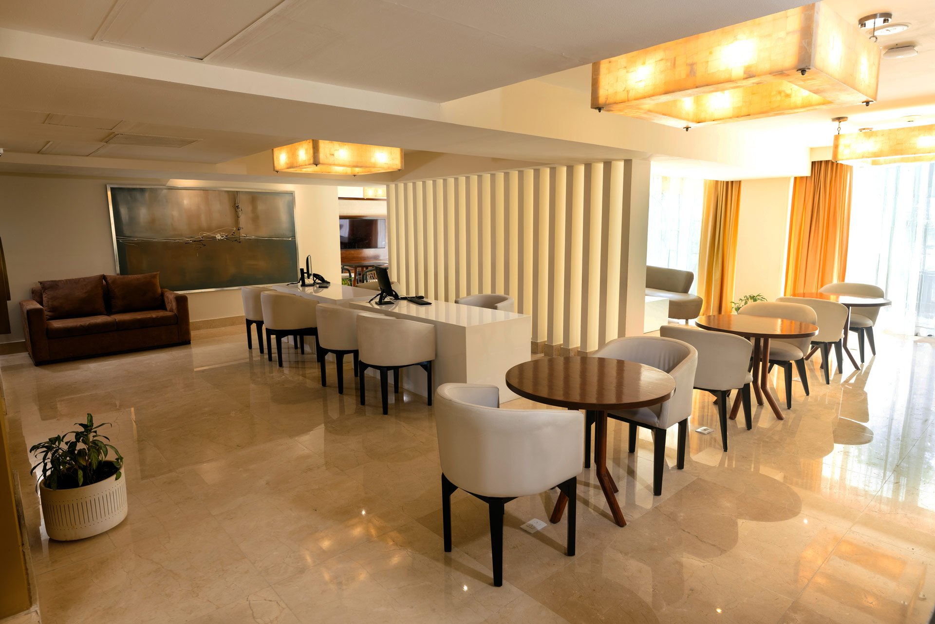 a room with white chairs and tables