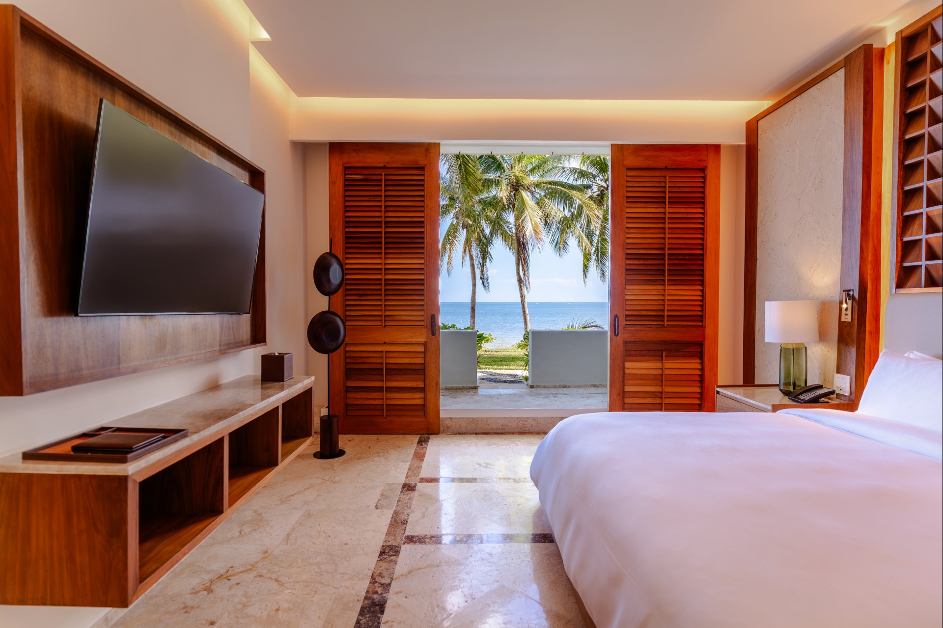 a bedroom with a television and a view of the ocean