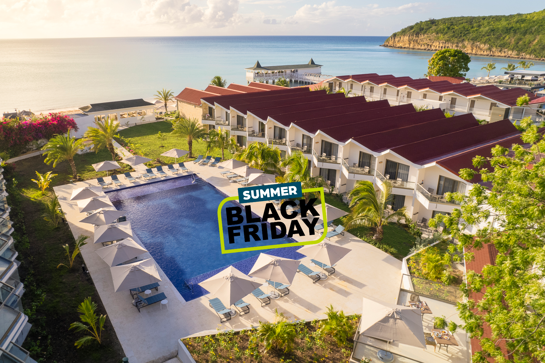 a pool and buildings with a beach and a body of water