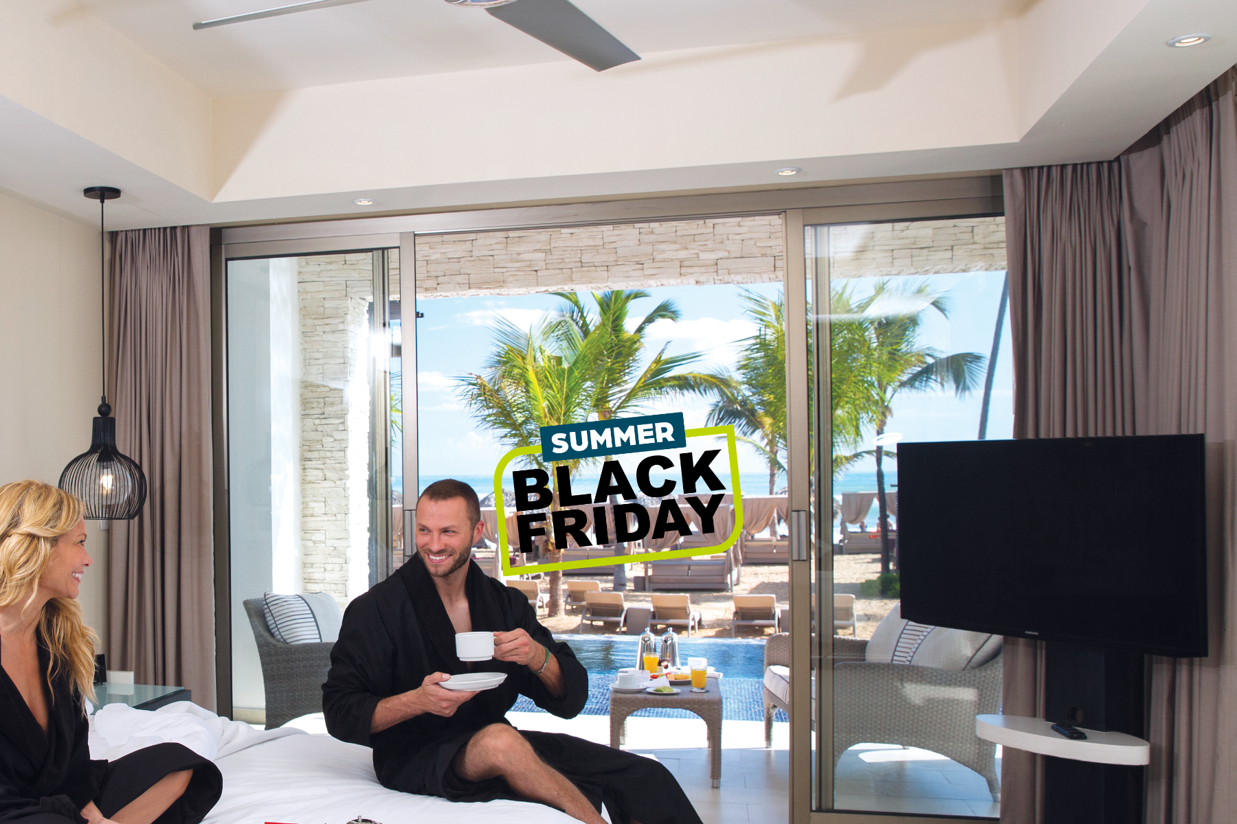 a man sitting on a bed with a cup of coffee