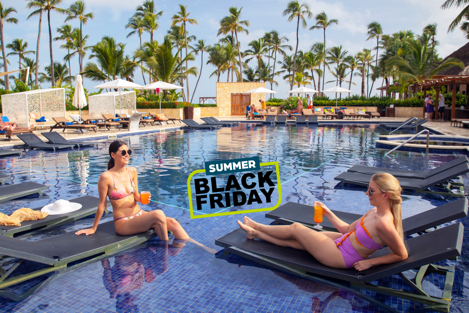 a group of women sitting on lounge chairs in a pool