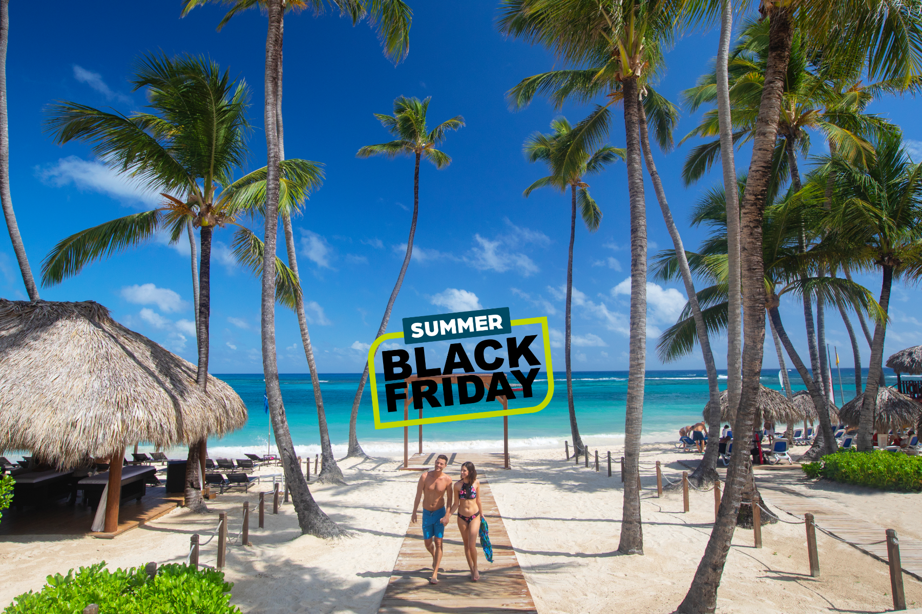 a man and woman walking on a path with palm trees and a beach