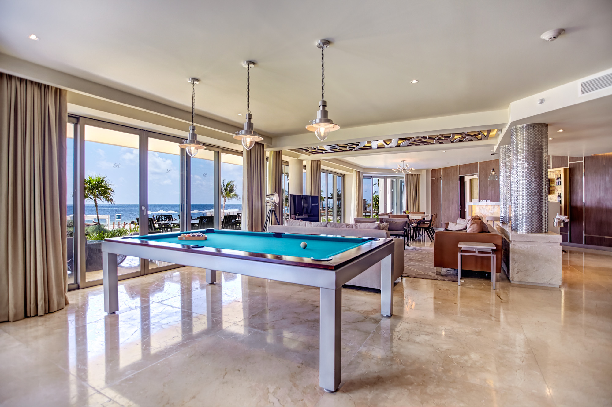 a pool table in a room with a view of the ocean