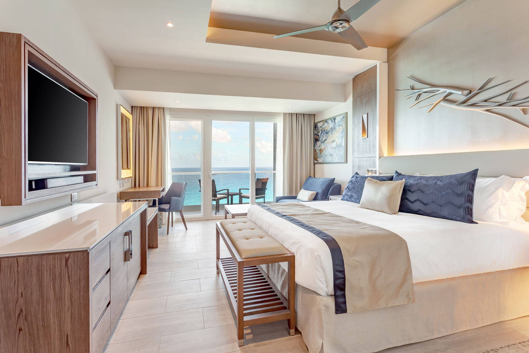 a room with a bed and a window with a view of the ocean