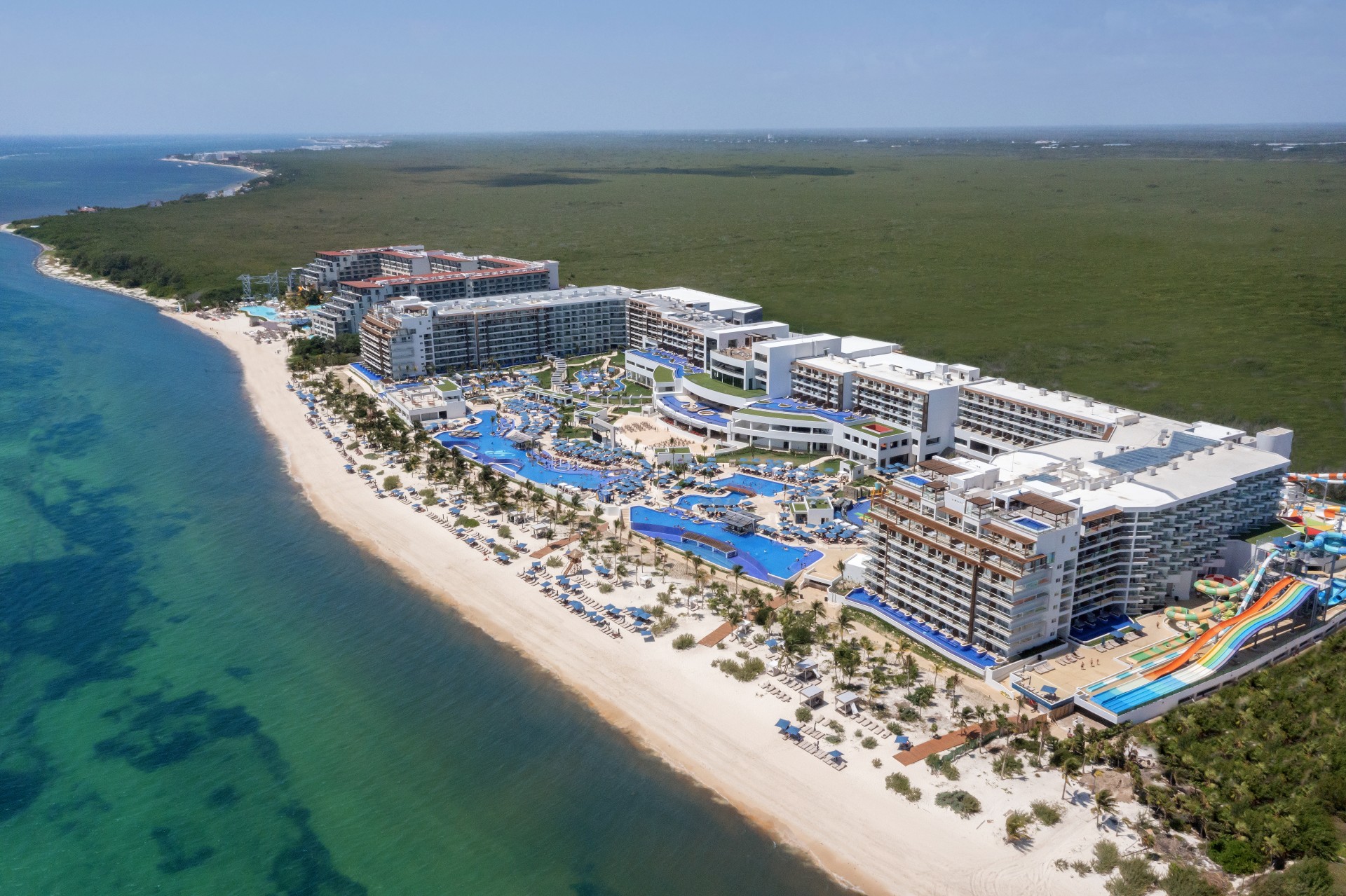 a beach with a large building and a pool