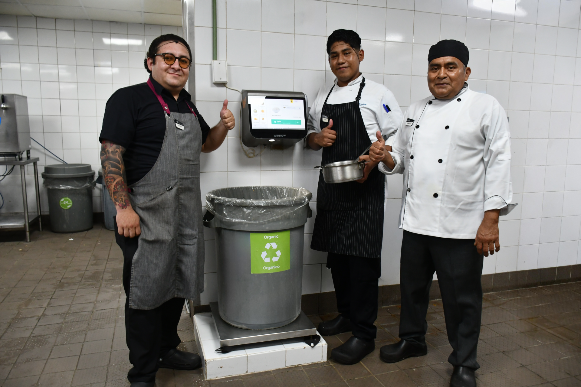 a group of men standing next to a garbage can