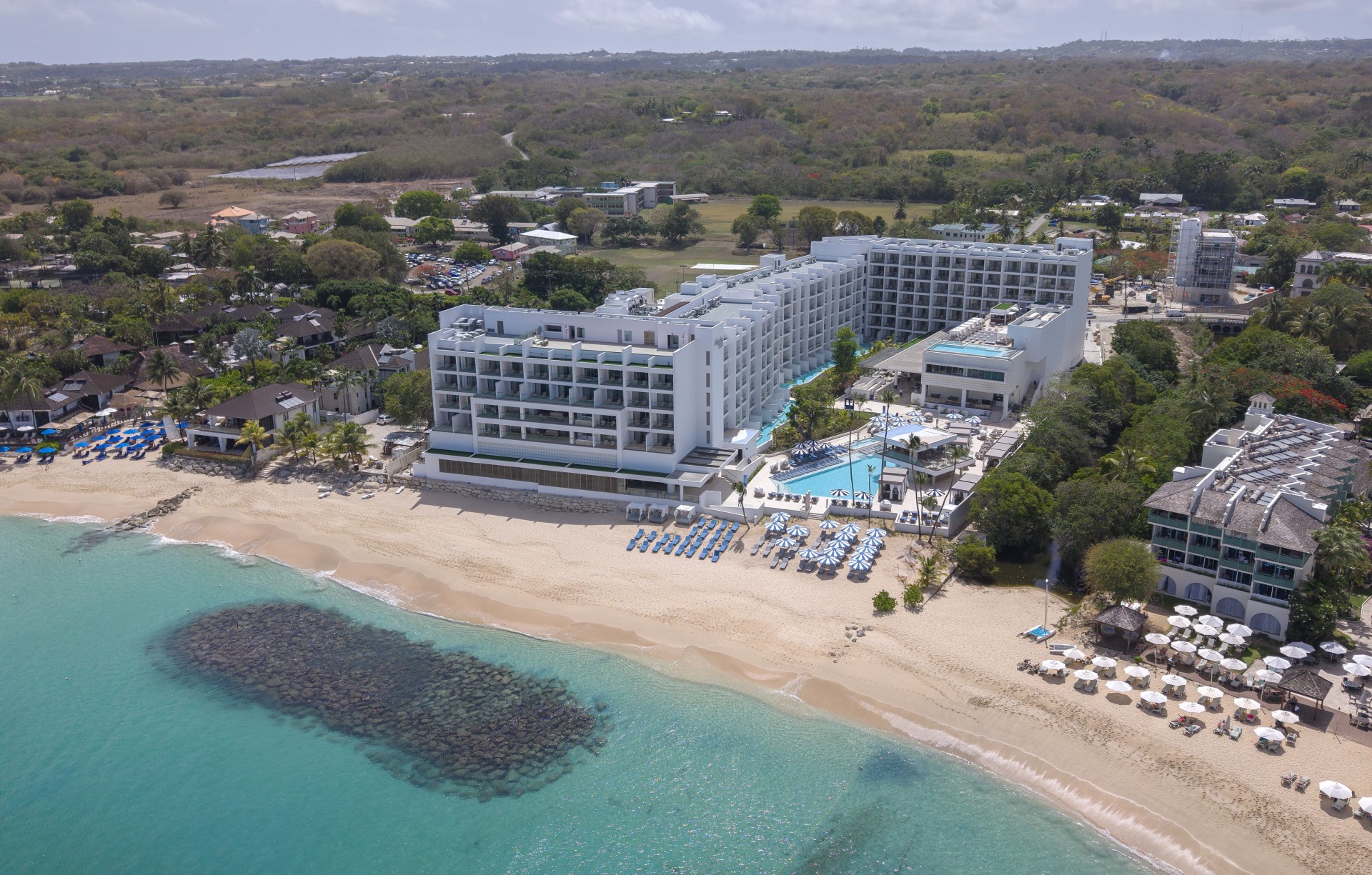 a large building with a pool on a beach