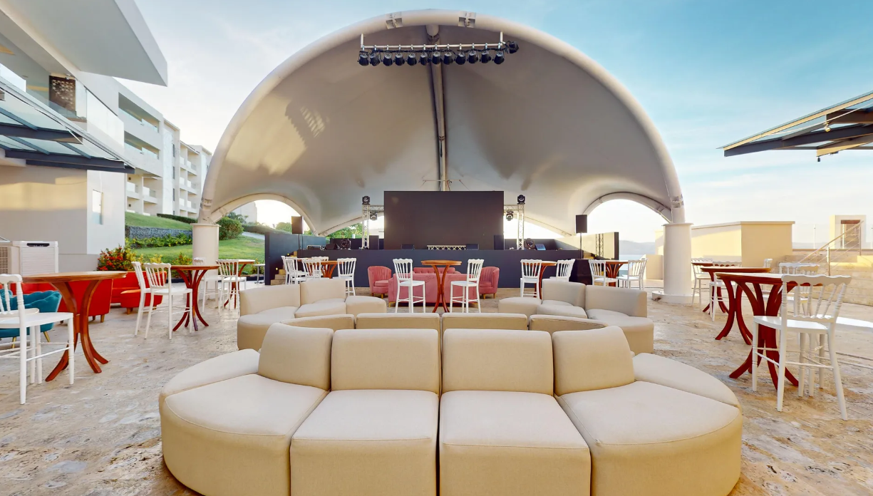 a large outdoor seating area with a stage and a large screen