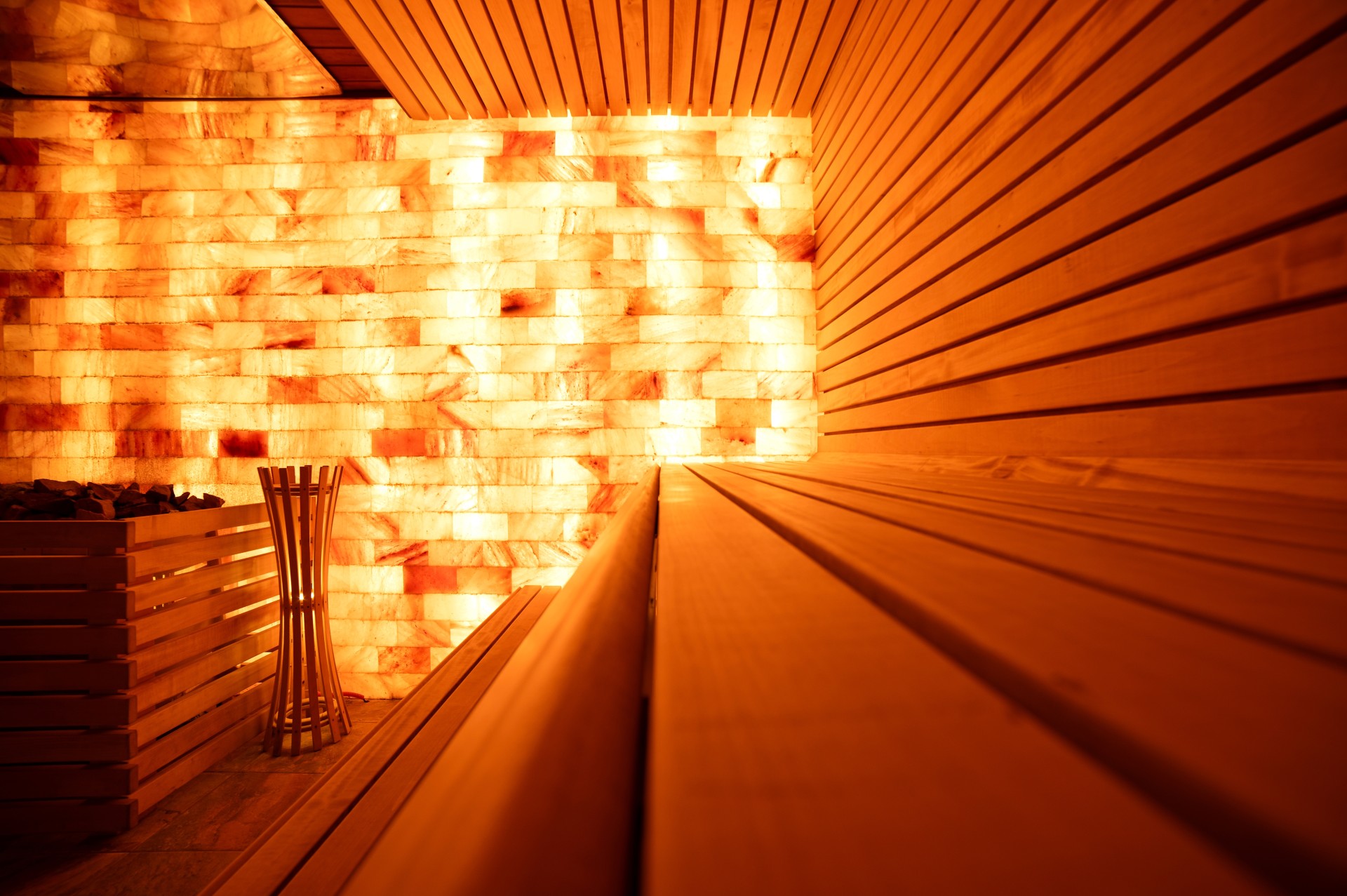 a wooden bench in a room with a light behind it