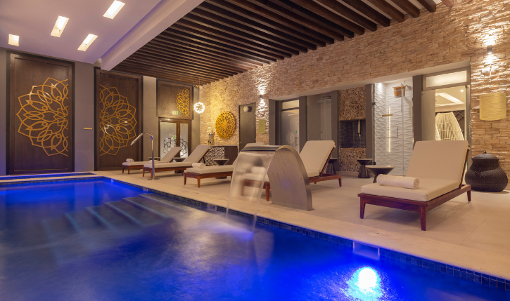 a pool with a waterfall and chairs