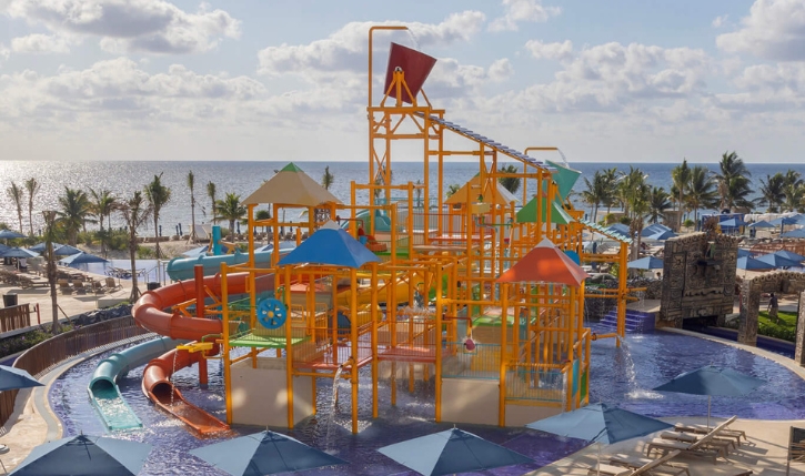 a water park with a slide and umbrellas