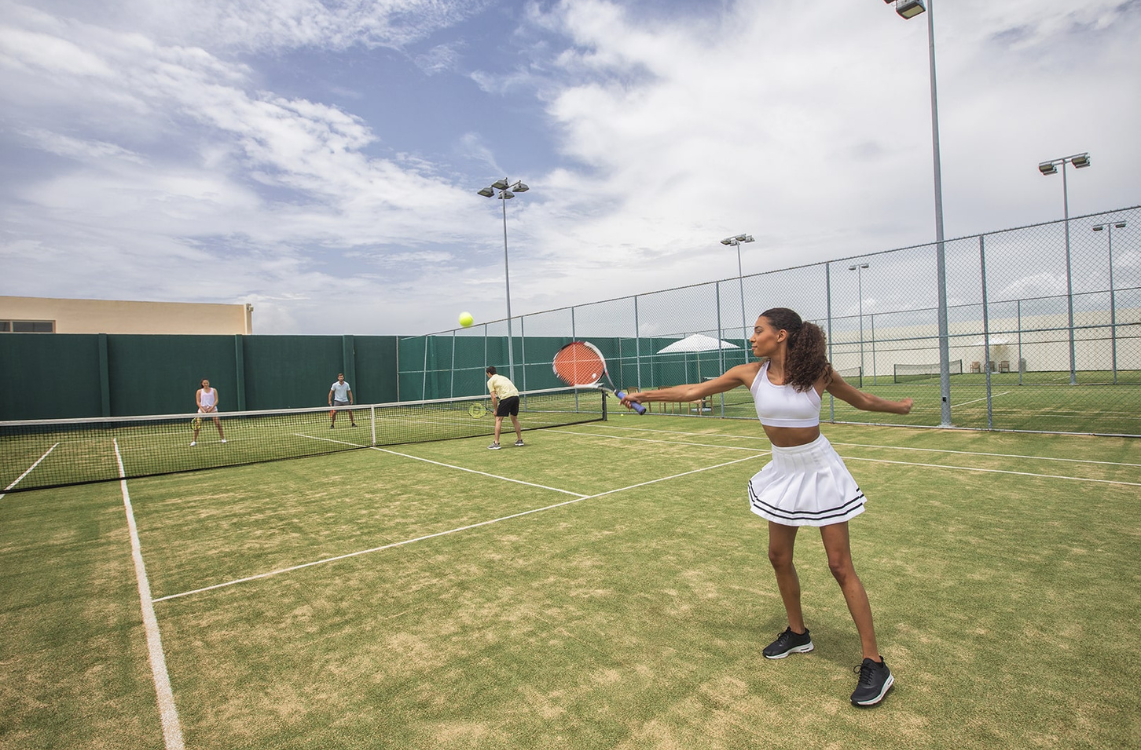 a woman holding a tennis racket and a ball