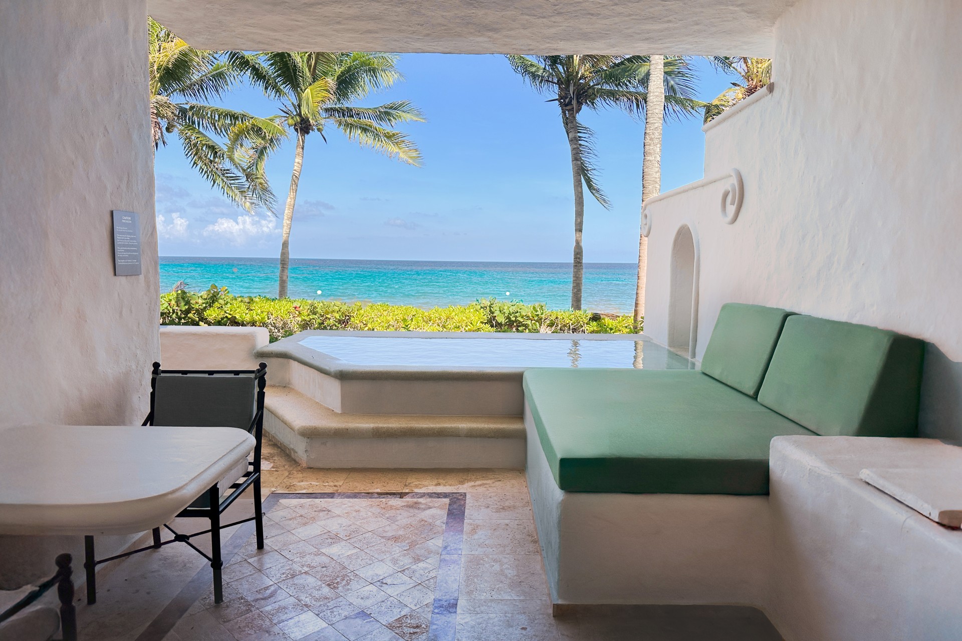 a patio with a view of the ocean and palm trees