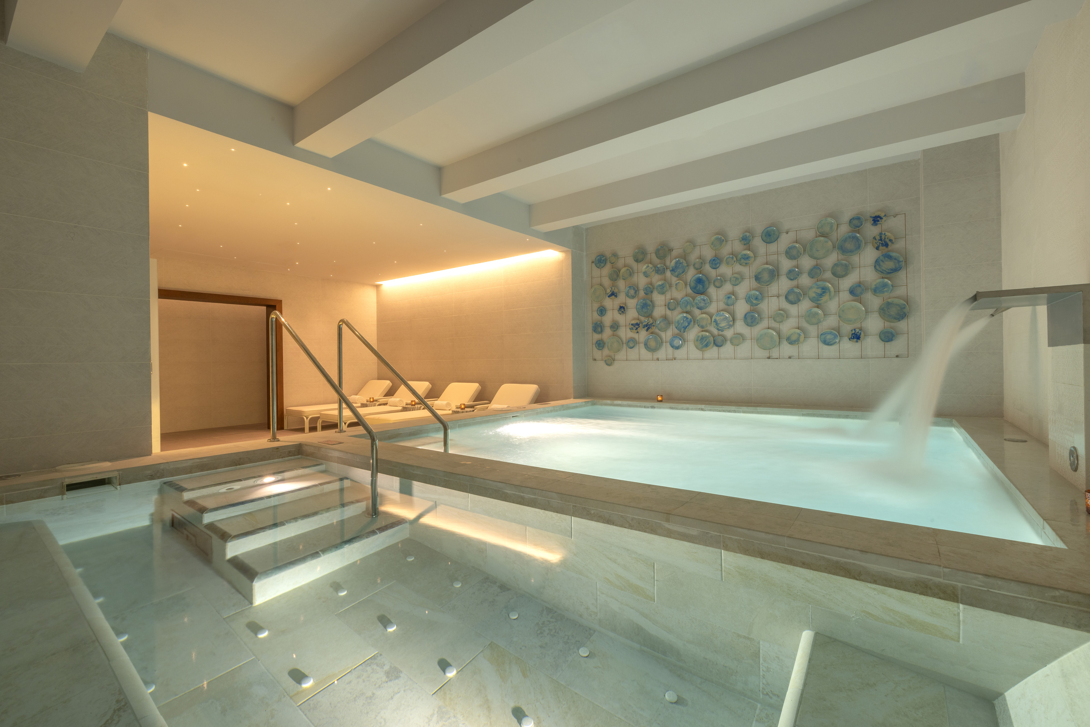 a indoor pool with a staircase and chairs