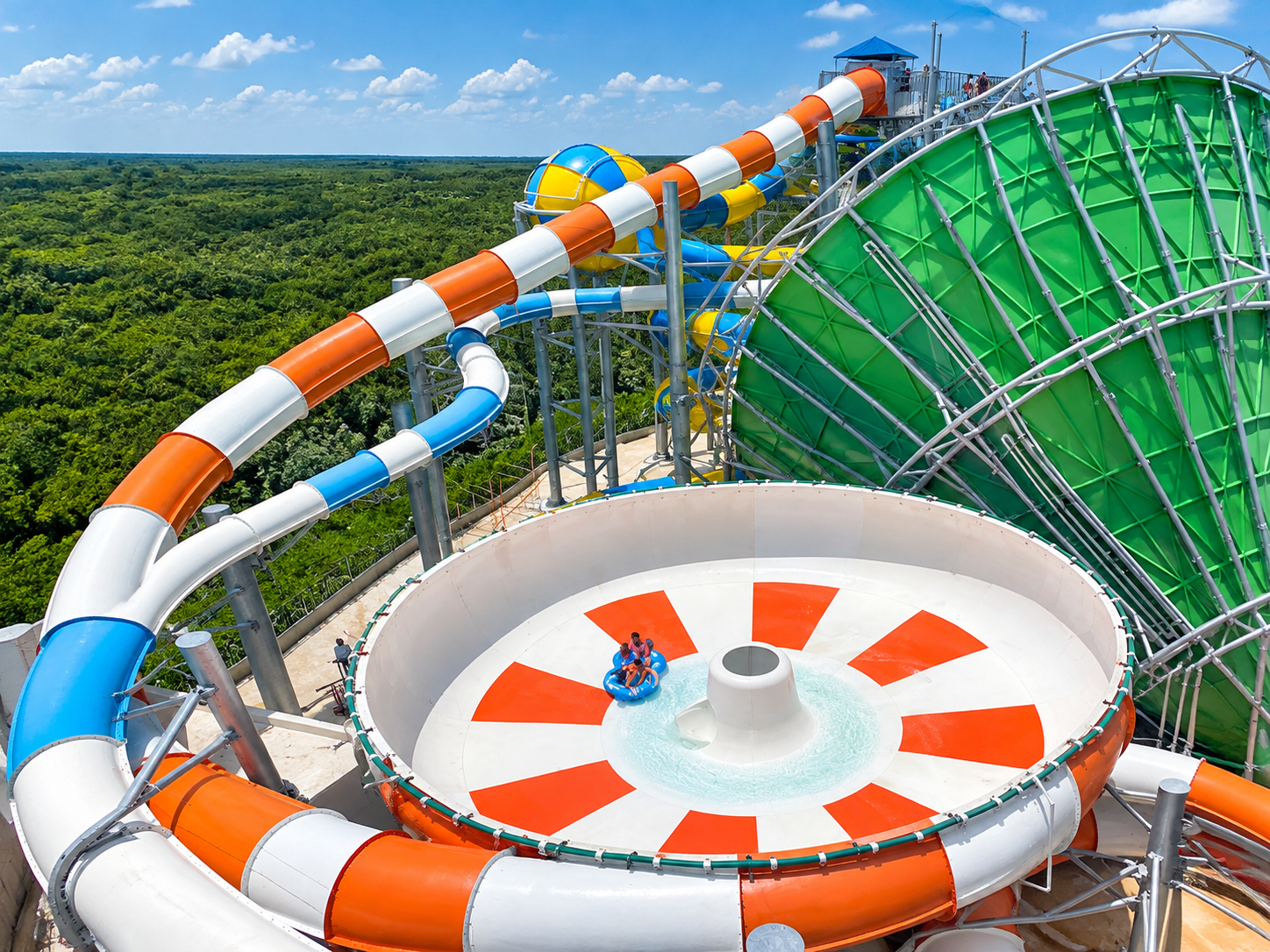 a water slide with a tube and a green forest
