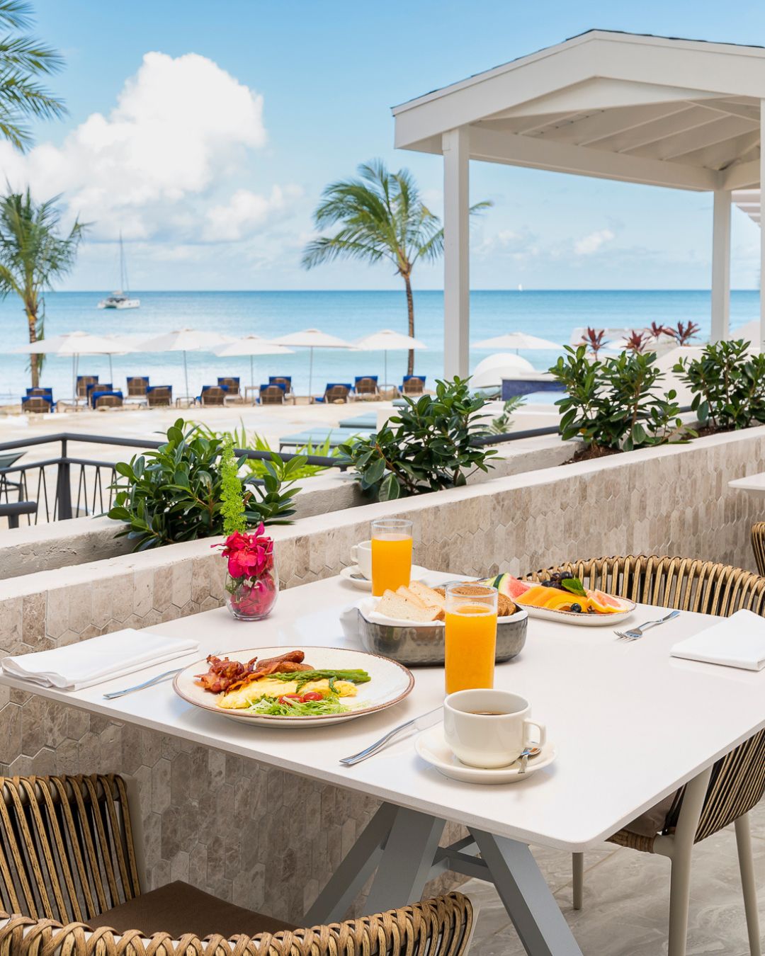a table with food on it and a beach in the background