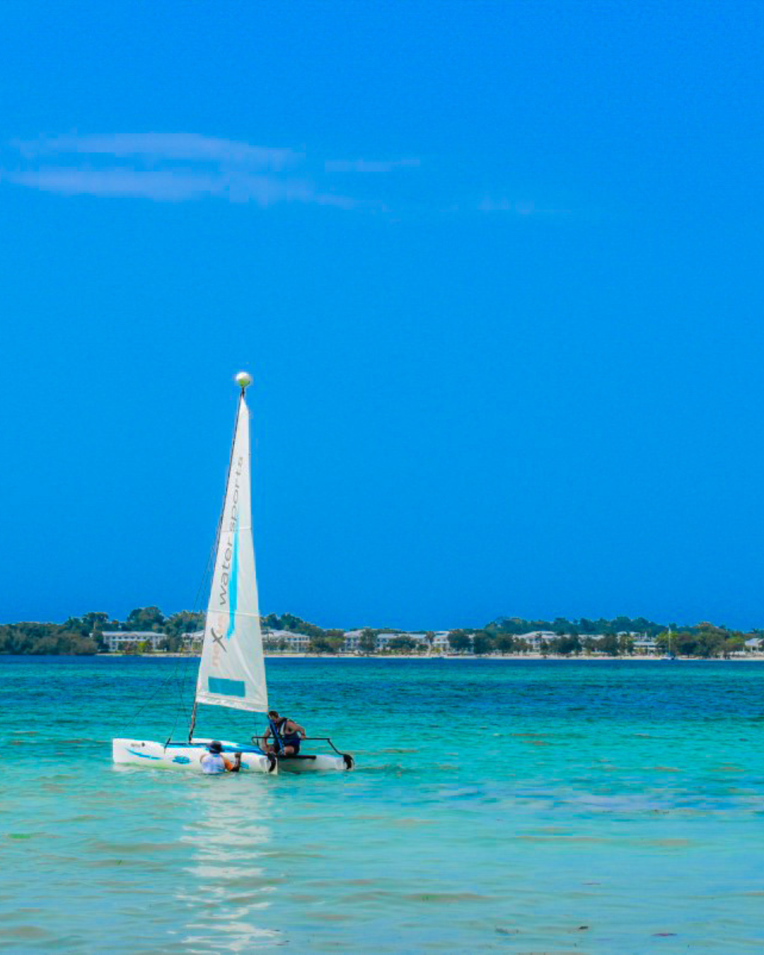 a person on a small sailboat in the water