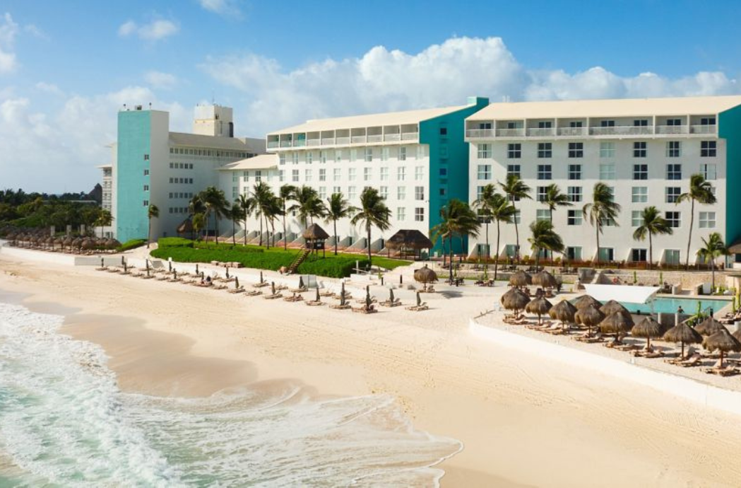 a beach with a building and palm trees