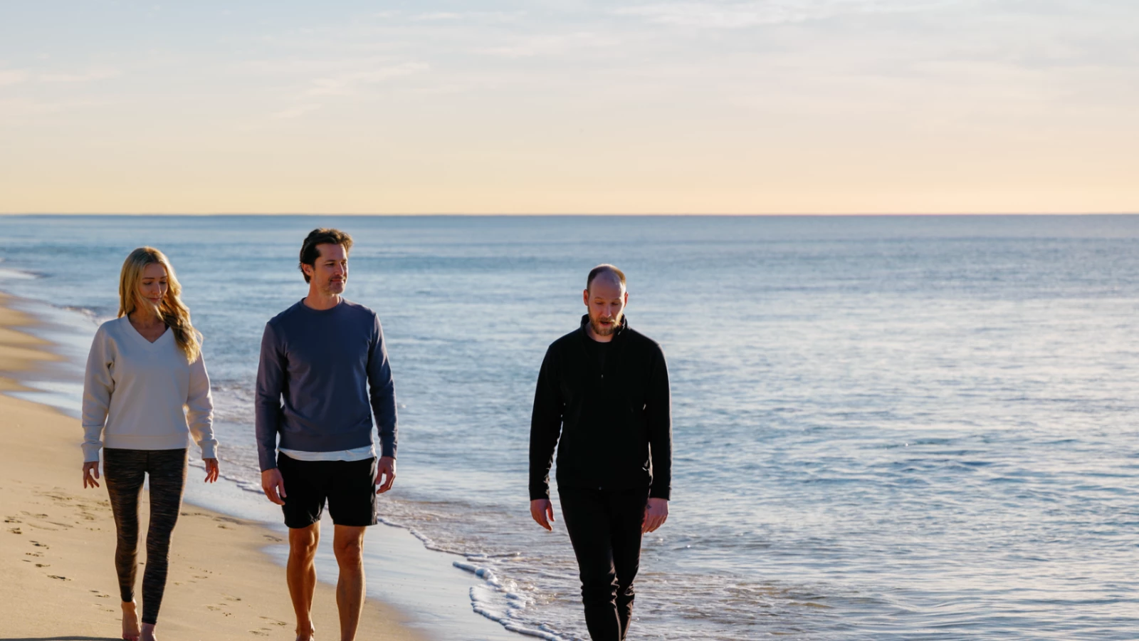 two men walking on a beach