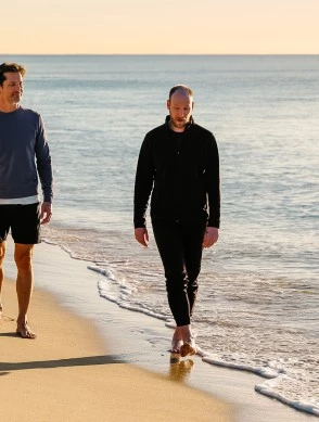 two men walking on a beach