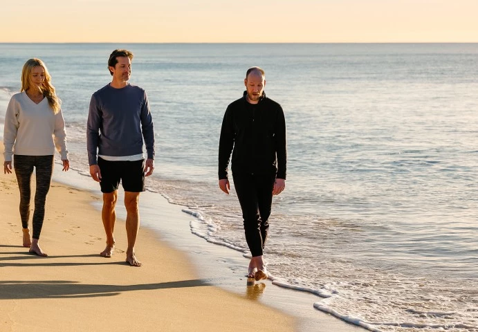 two men walking on a beach