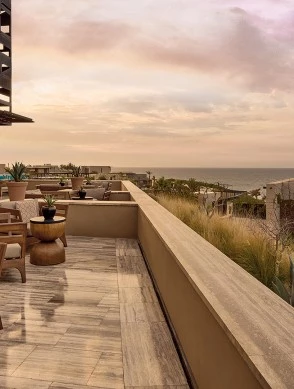 a patio with chairs and plants on the deck