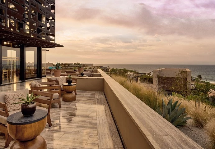 a patio with chairs and plants on the deck