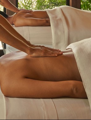 a man and woman lying on a bed with their hands on the back