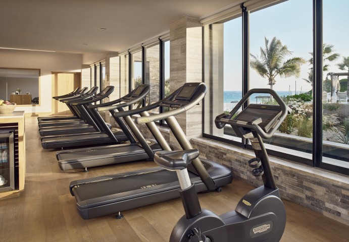 a group of treadmills in a room with windows