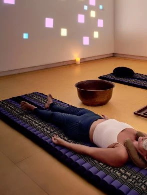 a woman lying on a mat with a mask on her face