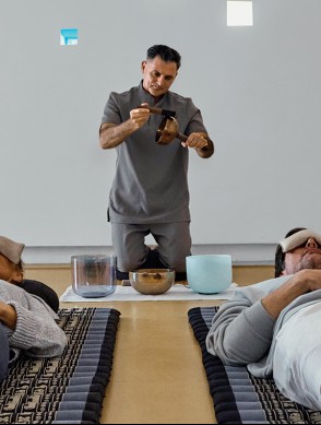 a man holding a bowl and a bowl with a bowl on a bed
