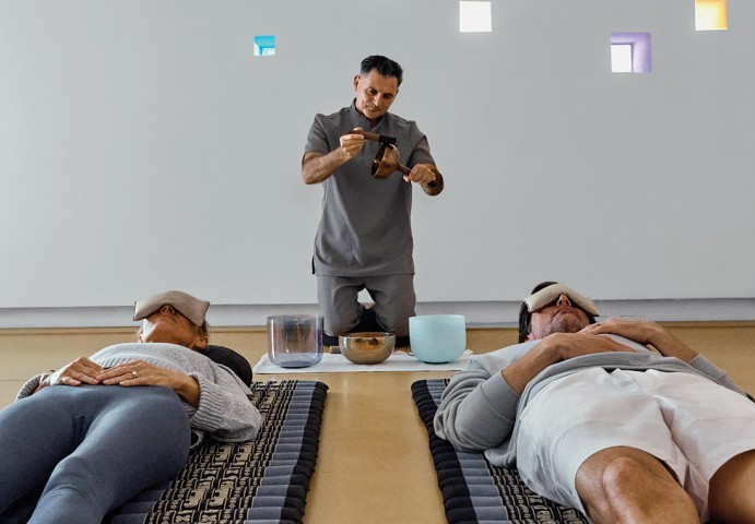 a man holding a bowl and a bowl with a bowl on a bed