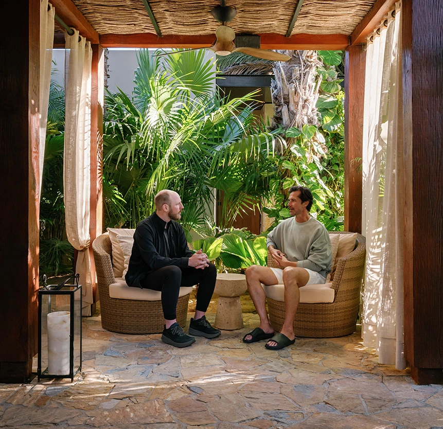 two men sitting in chairs in a gazebo