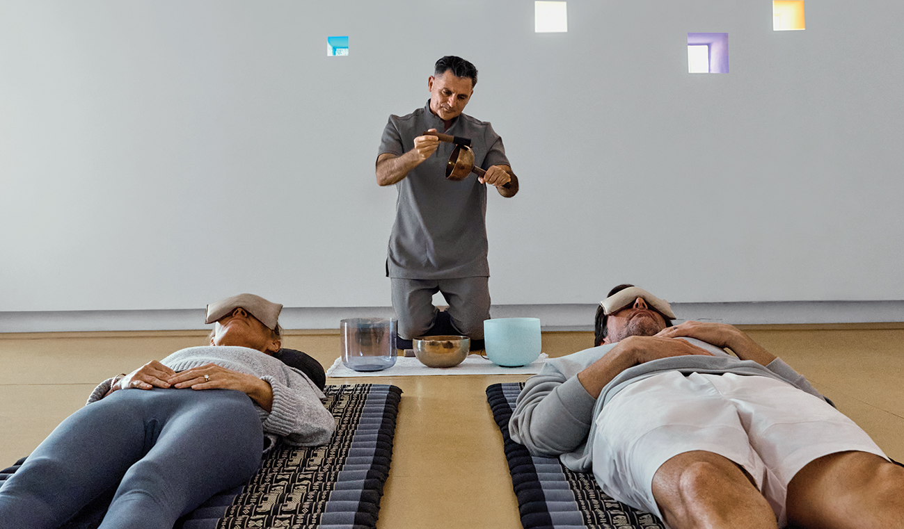 a man holding a bowl and a bowl with a bowl on a bed