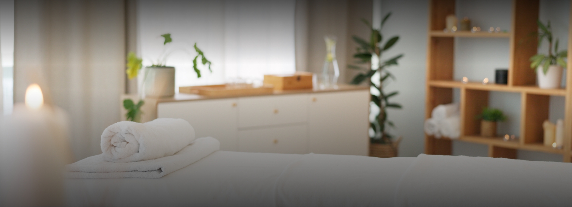 a white bed with a white towel on it