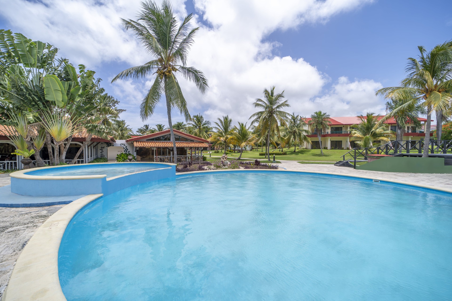 a pool with palm trees and buildings in the background