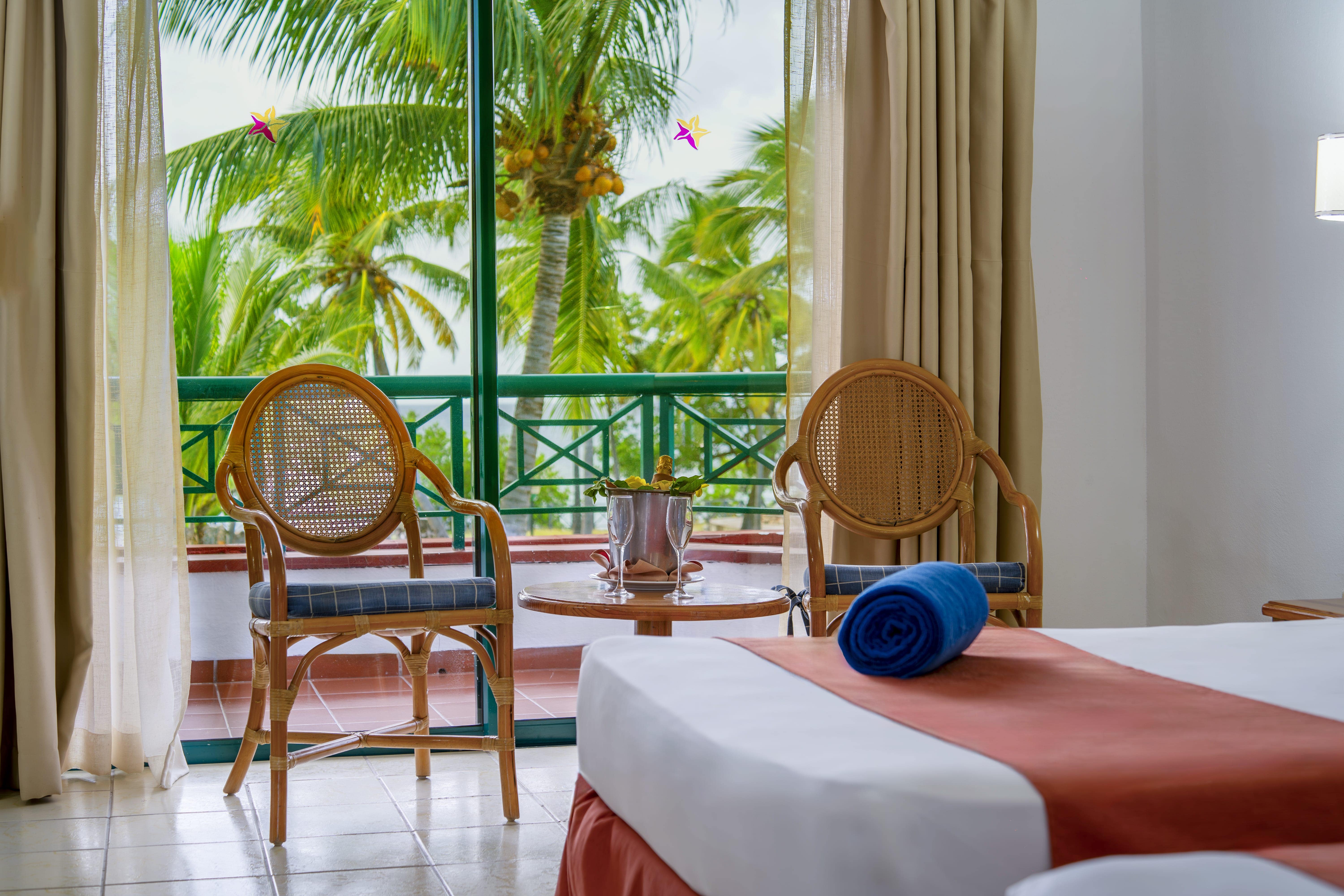 a room with a balcony and chairs and a table